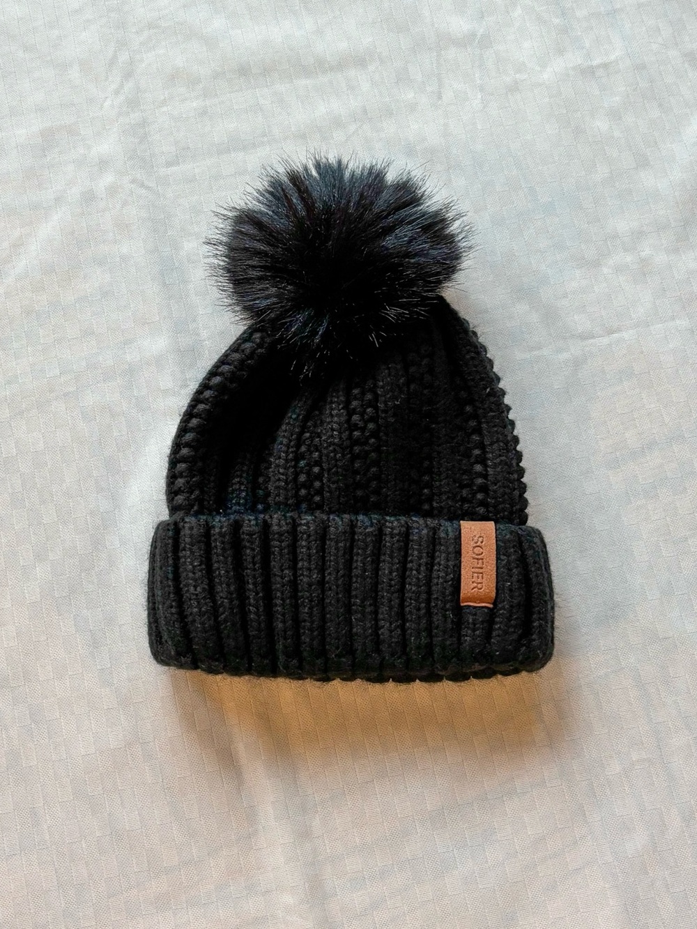 Black knit beanie with faux fur pom pom